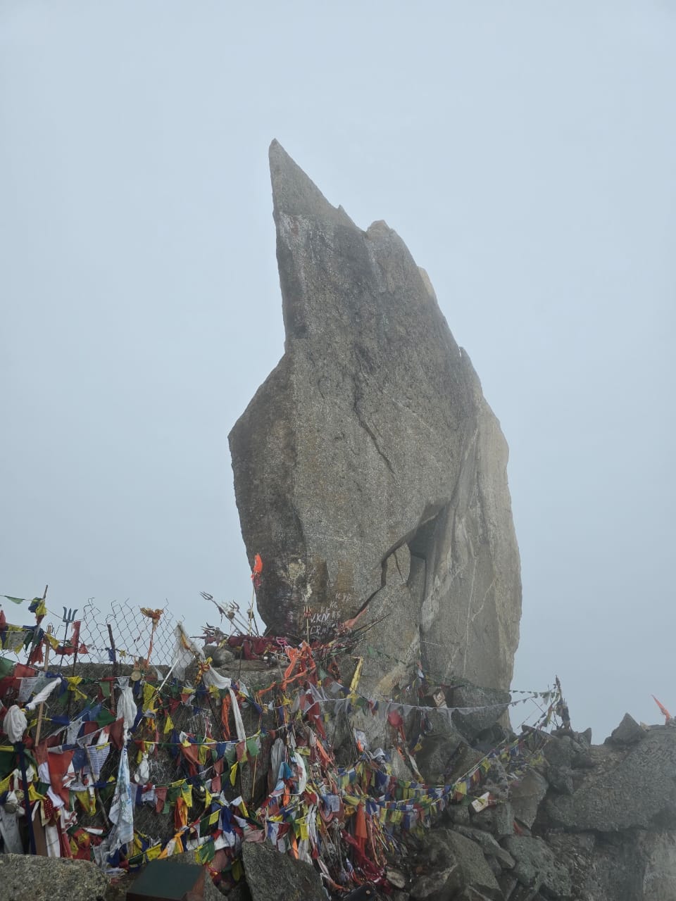 Lone trekker on a rocky trail above a deep Himalayan valley — trekking trails in Himachal Pradesh
